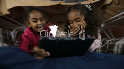 Excited girls playing online games on touchpad