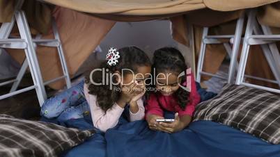 Little girls with phone browsing social networks