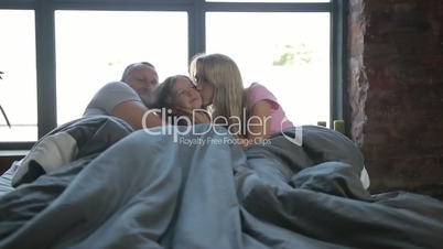 Carefree family enjoying in bed in the morning