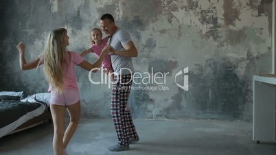 Carefree family with daughter dancing in the room