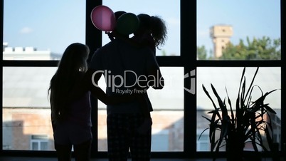 Silhouette of happy family embracing near window