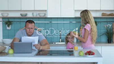 Confused man with laptop analyzing home finances