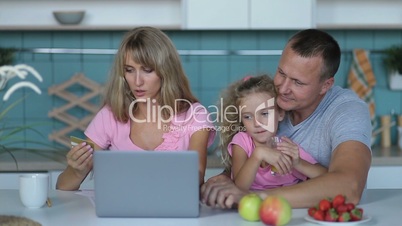 Joyful family shopping online with laptop at home