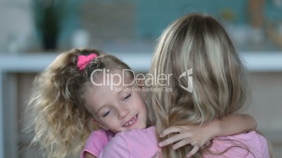 Cute daughter embracing mother with love at home