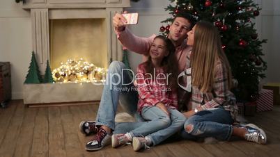 Cheerful family making christmas selfie at home