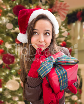 Thinking Girl Wearing A Christmas Santa Hat with Bow Wrapped Gif