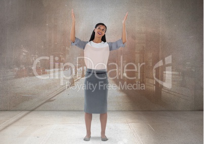 Businesswoman with arms open up to the sky in city room