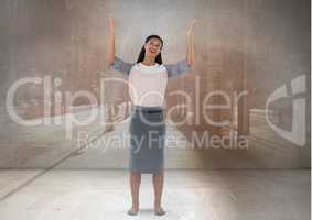 Businesswoman with arms open up to the sky in city room