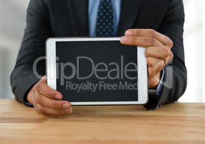 Businessman with tablet at desk with bright background