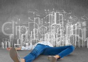Person lying with creative burnout exhaustion by city drawings