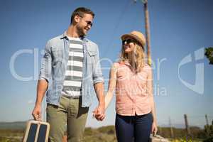 Couple walking with their luggage on a sunny day