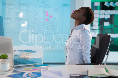 Female executive performing yoga at desk