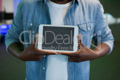 Mid section of male executive holding digital tablet