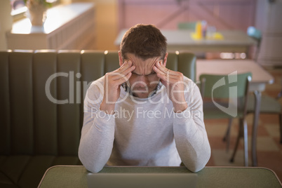 Depressed man sitting in restaurant