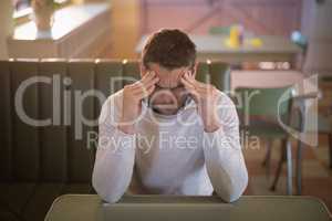 Depressed man sitting in restaurant