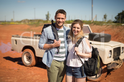 Couple standing together with backpack on a sunny day