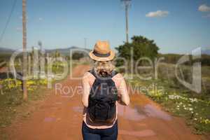 Woman standing with her backpack on a sunny day
