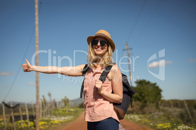 Woman hitchhiking on a sunny day