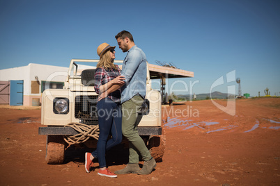 Couple romancing near a car on a sunny day