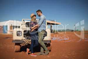 Couple romancing near a car on a sunny day