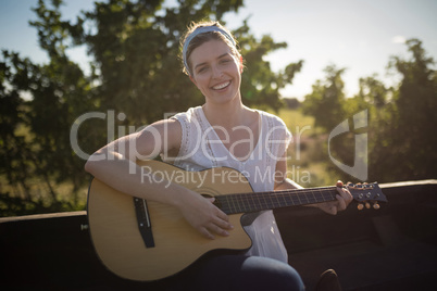 Woman playing guitar in a car