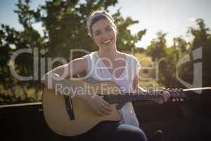 Woman playing guitar in a car