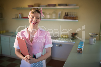 Waitress standing with menu card in restaurant