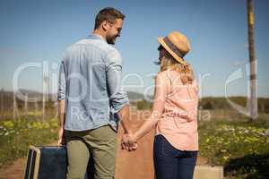 Couple walking with their luggage on a sunny day