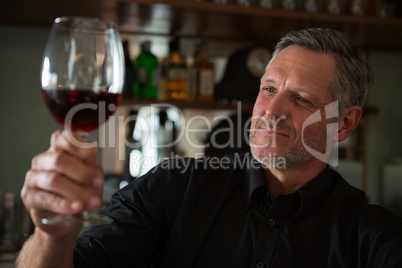 Waiter looking at a glass of wine