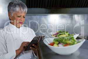 Female chef using digital tablet