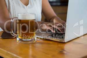 Woman using laptop at bar