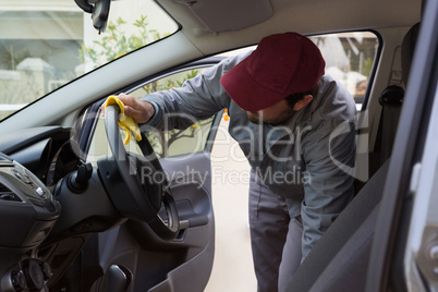 Auto service staff cleaning car interior