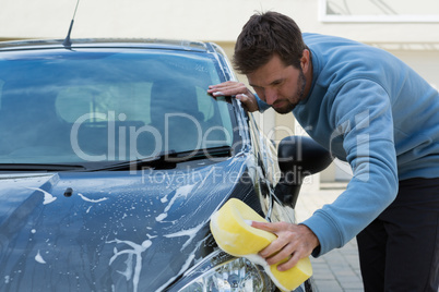 Auto service staff washing a car with sponge