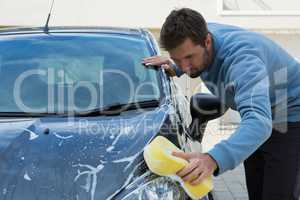 Auto service staff washing a car with sponge