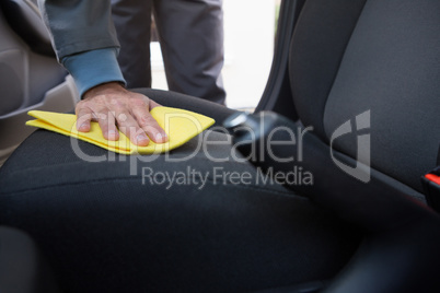 Worker cleaning seat inside the car