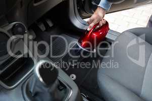 Auto service staff cleaning car with portable vacuum