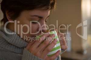 Woman drinking coffee in kitchen