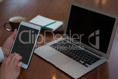 Woman using digital tablet at table