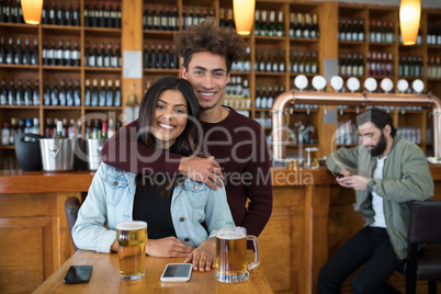 Smiling man embracing woman in bar