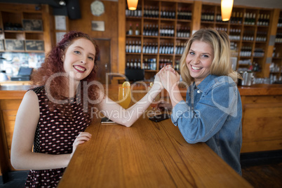 Friends holding hands in bar