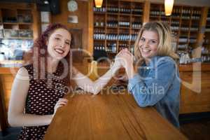 Friends holding hands in bar