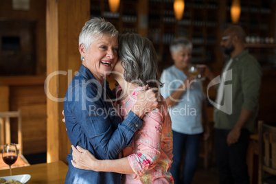 Two senior female friends embracing each other