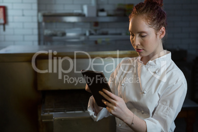 Female chef using digital tablet