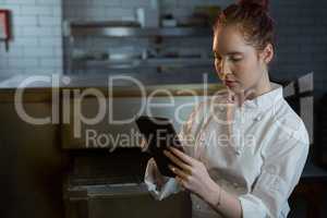 Female chef using digital tablet