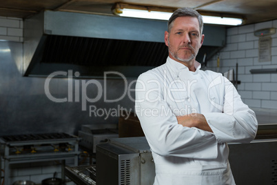 Smiling chef with hands crossed in the kitchen