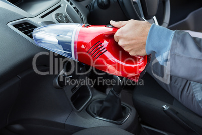 Auto service staff cleaning car with portable vacuum