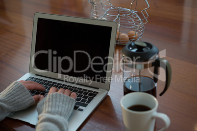 Woman using laptop in kitchen