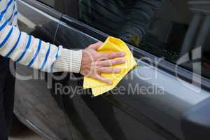 Auto service staff cleaning a car with duster