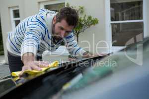 Auto service staff cleaning a car with duster