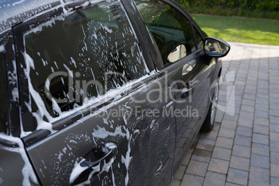 Half washed car with soap foam